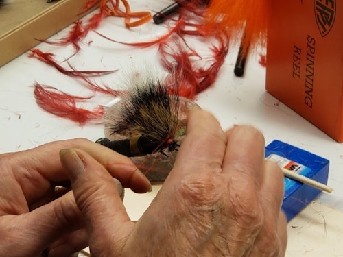 Each dressed hook on a Mepps spinner is tied by hand and paired with either a red or black hackle feather. 
