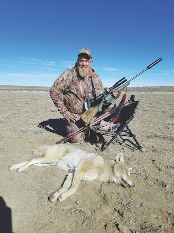 Al Morris proudly poses with a Western coyote. Check out the wide-open terrain in the background! Prime calling country.
