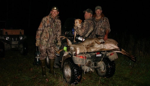 The author (left) was part of a rain-soaked blood trailing crew who finally found his buddy’s archery buck. 