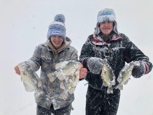 Even when the weather is nasty, the author’s son (left) and his buddies actively hole-hop without the aid of a shelter to stay on active crappies.