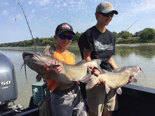 Luke (left) and his brother, Elliott, showing off a pair of Red River channel cats.