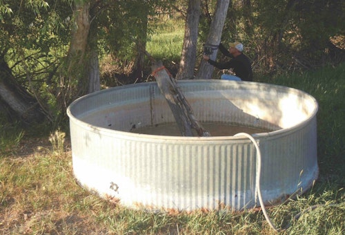 Water can a play a decisive role in grabbing the attention of a thirsty buck for a few quick snaps. The author sets a camera as he fills a tank from a nearby well site.