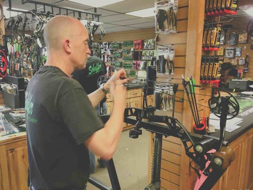 John Schaffer ties in a peep sight for a customer at his archery shop in Burnsville, Minnesota.